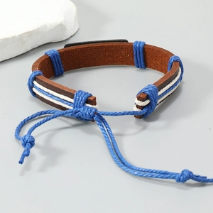 Detail of hand-woven leather bracelet featuring blue accents and a black metal plate
