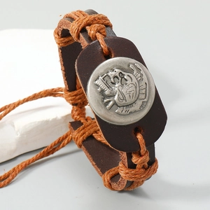 Macro detail of men's vintage leather bracelet with braided cord and embossed metal button