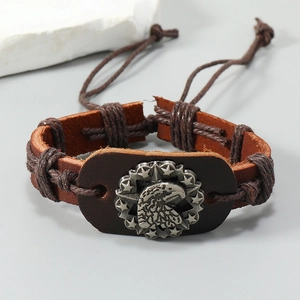 Macro detail of men's leather bracelet with vintage eagle emblem and woven cords