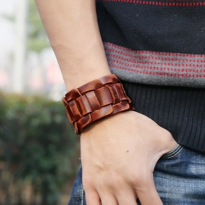Vintage brown genuine leather woven wide bracelet for men in an outdoor lifestyle setting