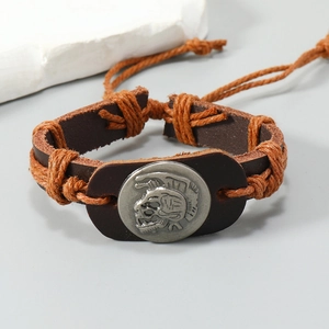 Detail of hand-woven leather bracelet featuring a vintage metal skull emblem and cord
