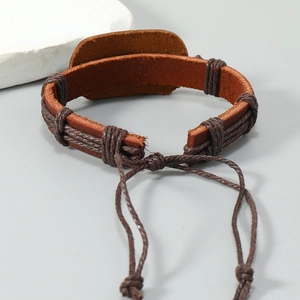 Detail of hand-woven brown leather bracelet featuring eagle style and braided rope textures