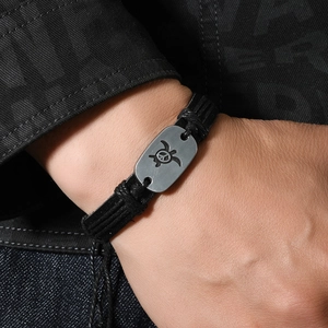 Braided leather beach bracelet with engraved turtle peace sign on a metal plate