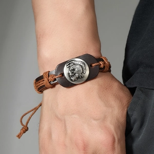 Retro handmade woven leather bracelet with vintage silver Mohawk medallion on a male wrist