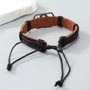 Macro detail of braided brown leather men's bracelet with dark grey metal plate inlay