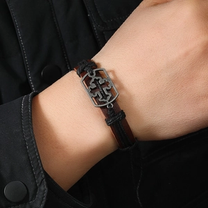 Men's retro leather braided bracelet with vintage silver cross charm on wrist