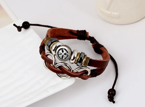 Detail of vintage multilayer leather bracelet with cross beads and adjustable cords