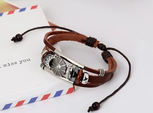 Detail of vintage multilayer braided leather bracelet with a silver star metal badge