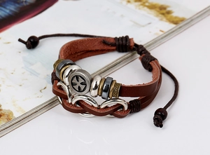 Detail of multi-layer leather bracelet with metal beads and Maltese cross charm pendant