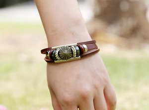 Detail of multi-layer leather bracelet with star metal charm and vintage beads