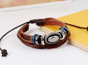 Dettaglio del bracciale multistrato in pelle intrecciata con ciondolo vintage e perline