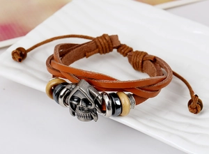 Detail of vintage leather bracelet with metal skull charms and adjustable braided cord