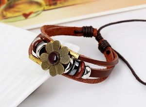 Macro detail of multi-layer leather bracelet with bronze flower and wooden beads