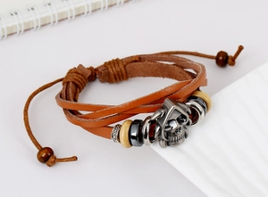 Macro view of braided leather layers, vintage metal skull charm, and adjustable cord closure