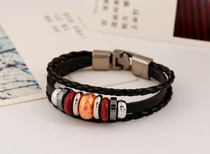 Macro detail of multilayer punk leather bracelet with orange bead and silver metal buckle