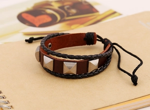 Macro detail of multi-layer leather bracelet with metal pyramid studs and snap button