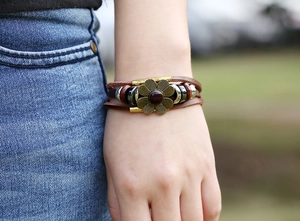 Detail of bohemian leather bracelet with alloy flower and beads on a model's wrist