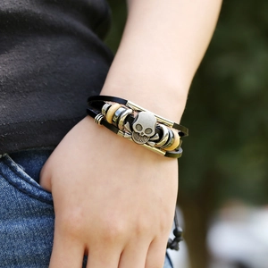 Handmade leather multilayer bracelet with skull charm and wooden beads on wrist