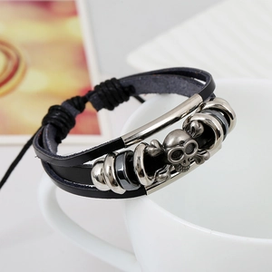 Bracciale multistrato in pelle punk con ciondolo teschio d'argento su tazza bianca