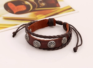 Detail of vintage multilayer braided leather bracelet with silver pattern rivets and cord