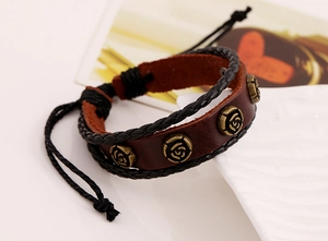 Détail du bracelet vintage en cuir marron avec rivets roses bronze et cordon tressé