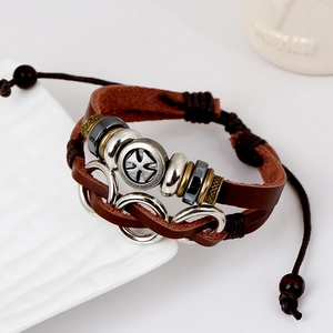 Vintage multilayer brown leather bracelet with metal beads and cross emblem on ceramic plate