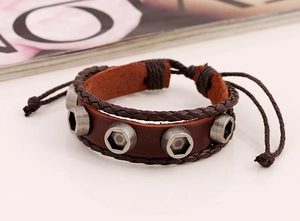 Close-up of vintage brown leather bracelet with silver hexagonal nuts and braided edges