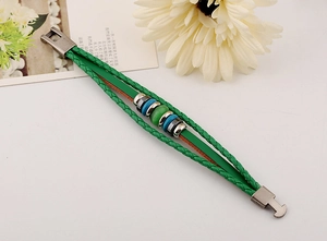 Detail of green multilayer leather bracelet with boho beads and retro metal clasp