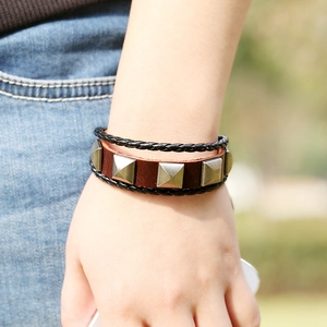 Multilayer vintage leather bracelet featuring wooden beads and silver pyramid studs