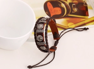 Macro view of multi-layer woven leather bracelet with vintage silver skull charms