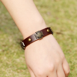 Bracelet vintage en cuir marron tressé avec croix en bronze et rivets au poignet
