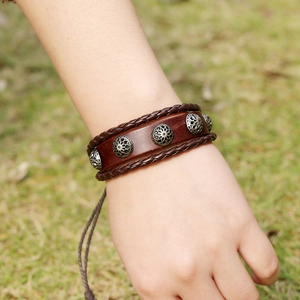 Retro brown braided leather bracelet with vintage metal studs shown on wrist