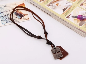 Macro shot of retro leather necklace with antique silver metal tag on a textured background