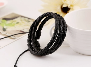 Detail of classic black multi-layer woven leather wrap bracelet with adjustable cords
