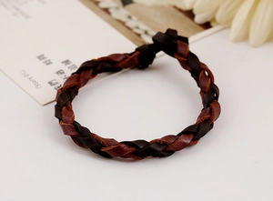 Dettaglio ravvicinato di un bracciale in vera pelle intrecciata bicolore stile retrò