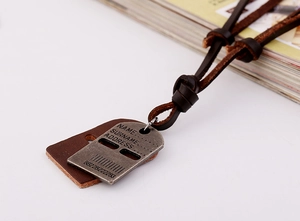 Close-up of vintage leather necklace with antique silver nameplate and brown base