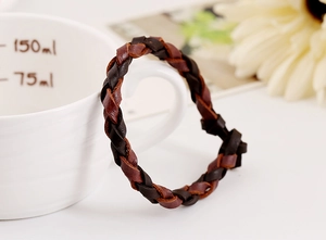 Dettaglio di bracciale in pelle intrecciata appeso a una tazza in stile retrò