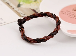 Dettaglio del bracciale in pelle intrecciata con design multistrato in stile vintage