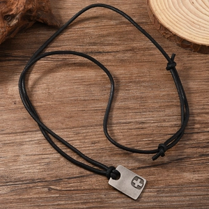 Detailed close-up of a vintage brushed metal cross pendant on an adjustable black cord
