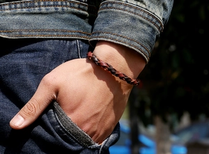 Dettaglio del bracciale vintage in pelle intrecciata a mano in marrone e rosso-marrone