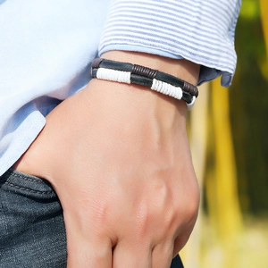 Close-up of men's braided leather bracelet with contrast stitching on model wrist