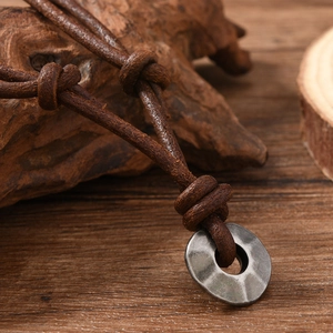 Adjustable vintage leather necklace featuring a hand-hammered textured metal ring pendant
