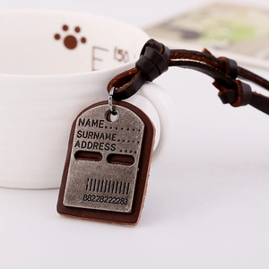 Retro mens genuine leather necklace with engraved alloy dog tag pendant on white desk
