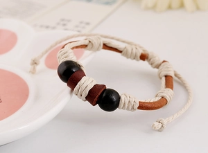 Detailed shot of handmade braided leather bracelet with wooden beads and adjustable cord