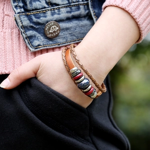 Handcrafted multilayer brown leather bracelet with colorful ceramic beads on a model's wrist