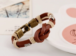 Gros plan détaillé du bracelet en cuir tressé marron avec nœud rétro et fermoir en bronze