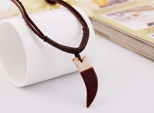 Détail d'un collier en cuir rétro avec pendentif en corne marron et crème