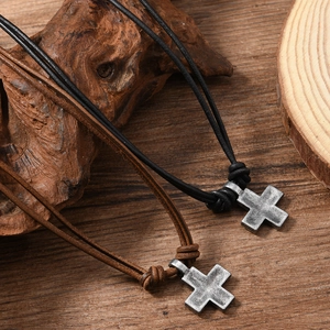 Retro woven leather cord necklace featuring two vintage cross pendants on wooden background