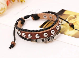 Detail eines verstellbaren Vintage-Punk-Lederarmbands mit Nieten und Lagen aus Perlen