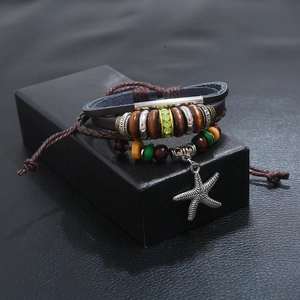 Handmade multilayer leather bracelet with a starfish charm and beads on a gift box